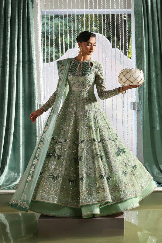 Lirien by Soraya luxury mint green couture pishwas outfit front view featuring heavily hand-embellished organza panels with intricate floral embroidery, resham threadwork, sequins, cutdana and tilla detailing arranged in elegant flowing pattern across flare, velvet accent neckline patch adding rich contrast, full embroidered sleeves and back panels, paired with lightweight net dupatta featuring embroidered sprays and delicate border finishing, along with dyed silk trouser, premium Pakistani designer outfit