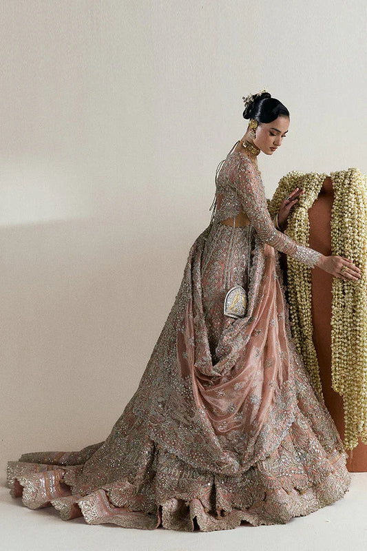 Suffuse Mahveen luxury bridal pishwas outfit front view featuring heavily hand-embellished tissue pishwas with fitted sleeves and layered bustier neckline, adorned with intricate mirror work, gota, resham and floral embroidery in sage green and gold accents, paired with richly panelled lehenga featuring ornate golden silver border detailing, completed with shikargah inspired tissue dupatta with geometric patterns, mirror work and four sided embroidered edges, premium Pakistani bridal couture