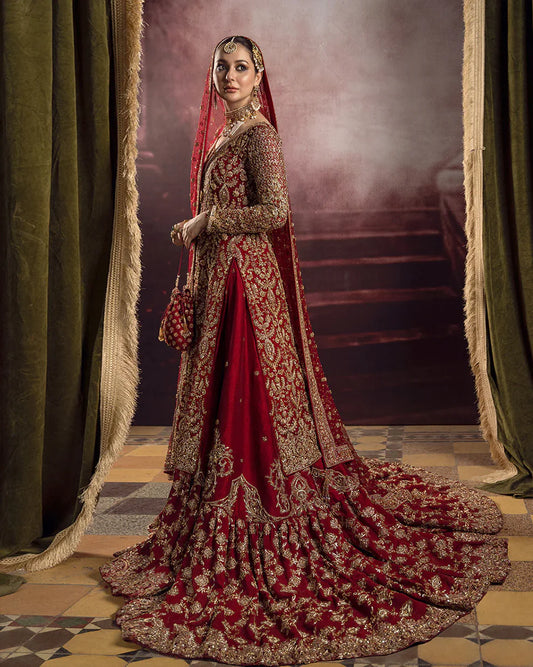 Roushana Faiza Saqlain luxury red bridal couture outfit front view featuring heavily hand-embellished chiffon pishwas with intricate dabka, marori, resham and zardozi embroidery forming traditional floral and vine motifs, richly detailed neckline and sleeves with full handwork, paired with Korean raw silk gharara with fine embellishment and flowing net dupatta adorned with heavy embroidery and ornate border finishing, premium bridal wedding dress perfect for brides, receptions and luxury festive occasions