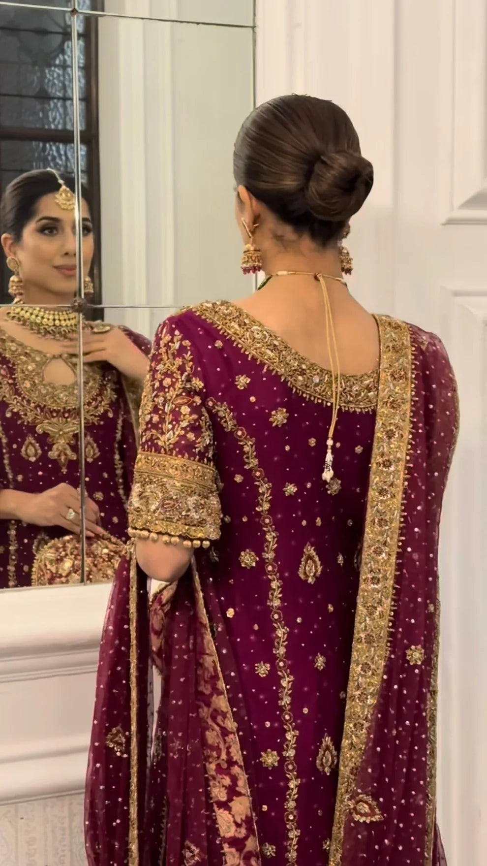 Libah by Haris Shakeel luxury formal outfit front view featuring deep maroon raw silk shirt with heavy all-over gold hand embroidery including intricate floral motifs, zari, resham and sequins work, elegant straight silhouette with richly decorated sleeves and ornate border finishing, paired with champagne toned straight trousers and sheer organza dupatta with subtle booti spray and detailed embroidered pallu, premium Pakistani designer outfit perfect for weddings, festive occasions, mehndi.