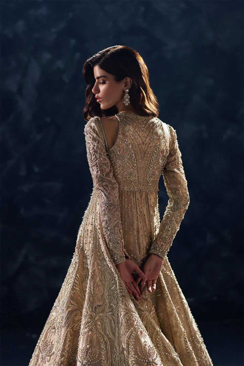 Reverie Soraya luxury gold tissue couture bridal gown front view featuring heavily hand-embellished upper bodice with intricate sheesha, dabka, naqshi and sequin embroidery in royal symmetrical pattern, structured flared silhouette with layered panels and flowing lehenga underlayer, richly detailed neckline and sleeves with fine hand embroidery, paired with heavily embroidered organza dupatta with sequins, dabka work and ornate border finishing, premium designer wedding outfit perfect for bridal wear.