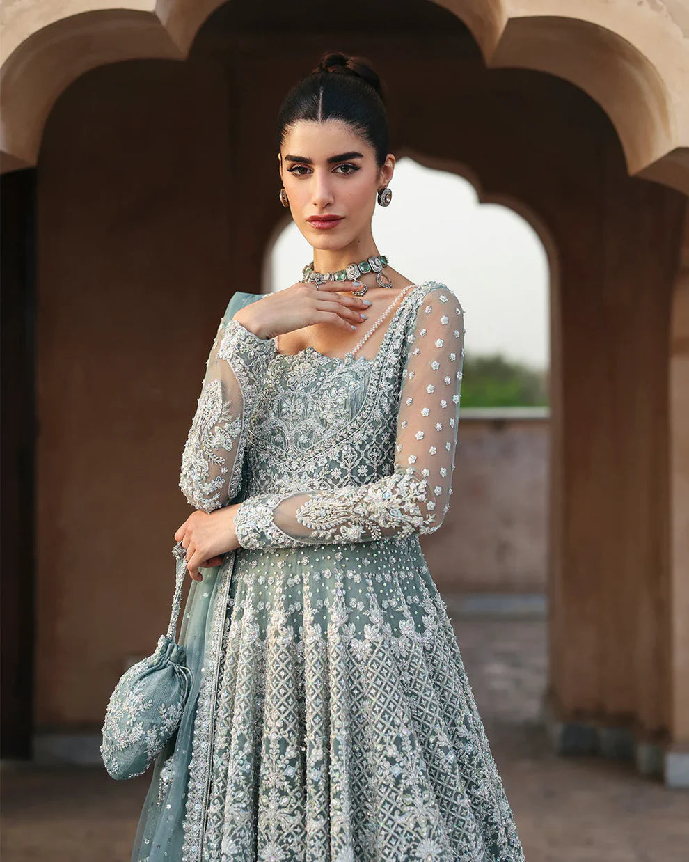 Dorien by Faiza Saqlain luxury mint blue bridal couture outfit front view featuring heavily hand-embellished net pishwas with intricate sequins, stones and resham embroidery in delicate floral heritage patterns, elegantly structured bodice with fitted sleeves and flowing flare silhouette, paired with richly embellished tissue lehenga featuring ornate embroidered borders and layered detailing, completed with heavily decorated net dupatta with all over sequin spray and four sided embroidered edging.