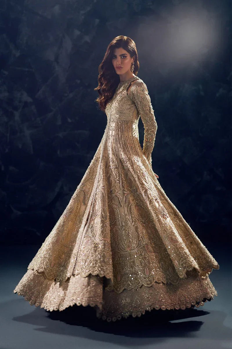 Reverie Soraya luxury gold tissue couture bridal gown front view featuring heavily hand-embellished upper bodice with intricate sheesha, dabka, naqshi and sequin embroidery in royal symmetrical pattern, structured flared silhouette with layered panels and flowing lehenga underlayer, richly detailed neckline and sleeves with fine hand embroidery, paired with heavily embroidered organza dupatta with sequins, dabka work and ornate border finishing, premium designer wedding outfit perfect for bridal wear.