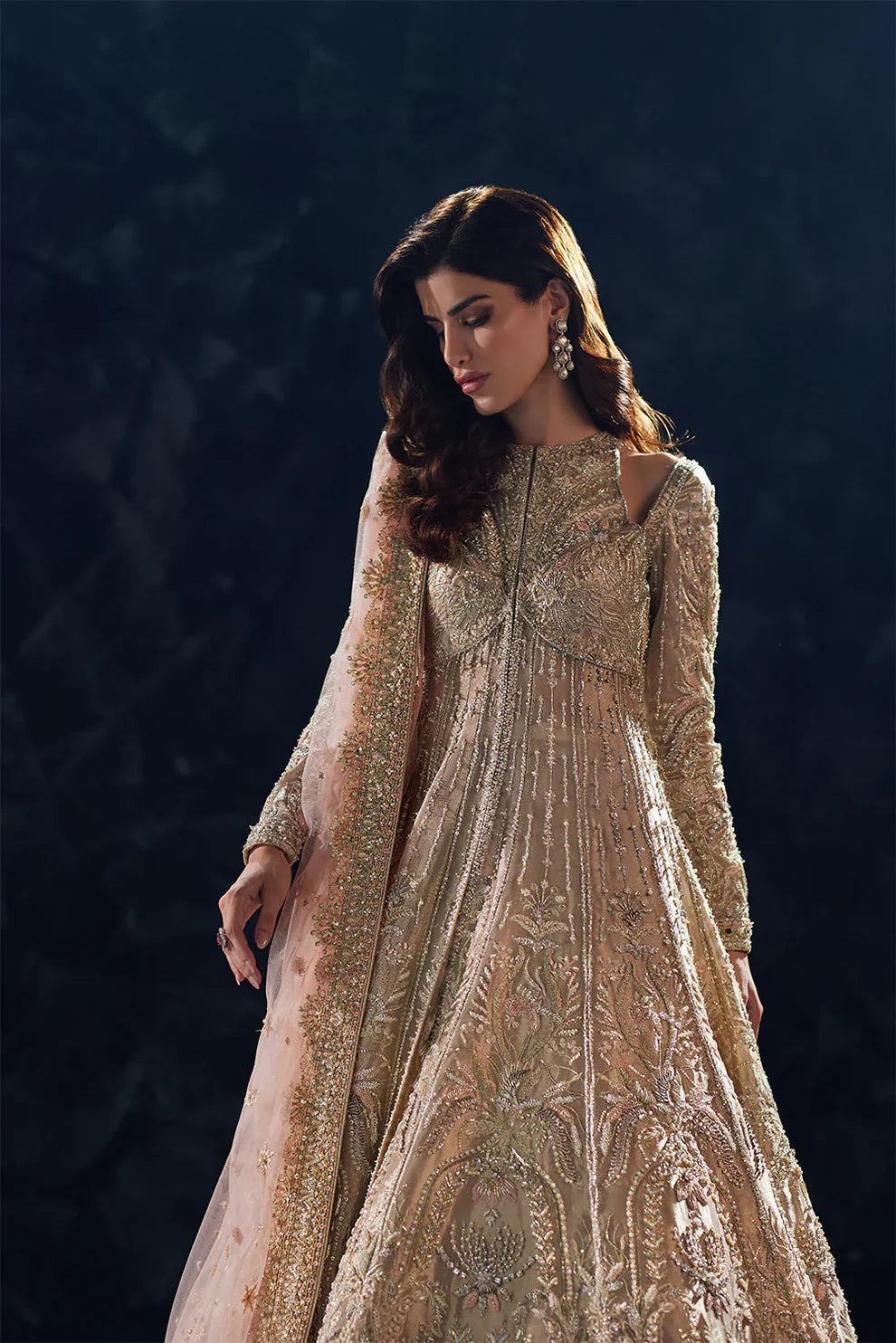 Reverie Soraya luxury gold tissue couture bridal gown front view featuring heavily hand-embellished upper bodice with intricate sheesha, dabka, naqshi and sequin embroidery in royal symmetrical pattern, structured flared silhouette with layered panels and flowing lehenga underlayer, richly detailed neckline and sleeves with fine hand embroidery, paired with heavily embroidered organza dupatta with sequins, dabka work and ornate border finishing, premium designer wedding outfit perfect for bridal wear.