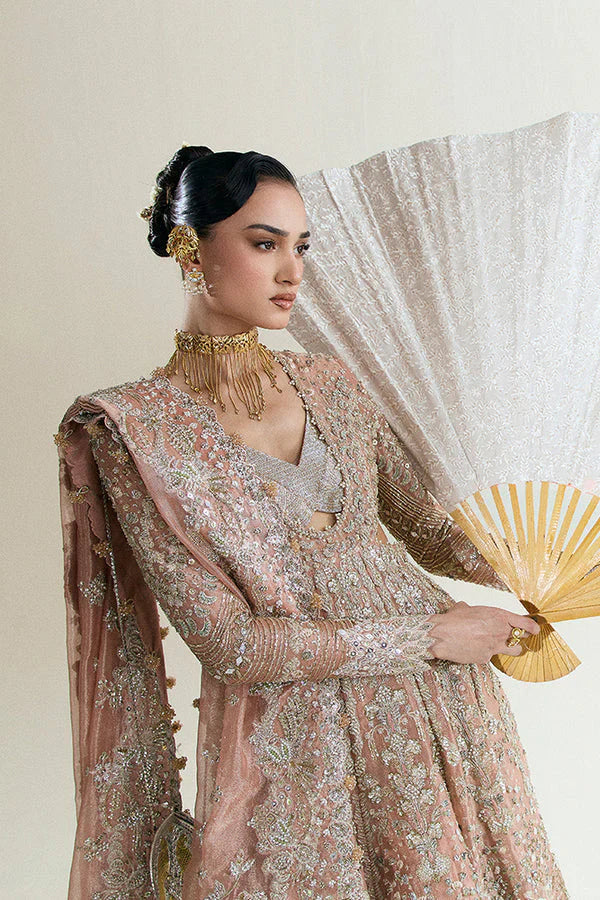 Suffuse Mahveen luxury bridal pishwas outfit front view featuring heavily hand-embellished tissue pishwas with fitted sleeves and layered bustier neckline, adorned with intricate mirror work, gota, resham and floral embroidery in sage green and gold accents, paired with richly panelled lehenga featuring ornate golden silver border detailing, completed with shikargah inspired tissue dupatta with geometric patterns, mirror work and four sided embroidered edges, premium Pakistani bridal couture 