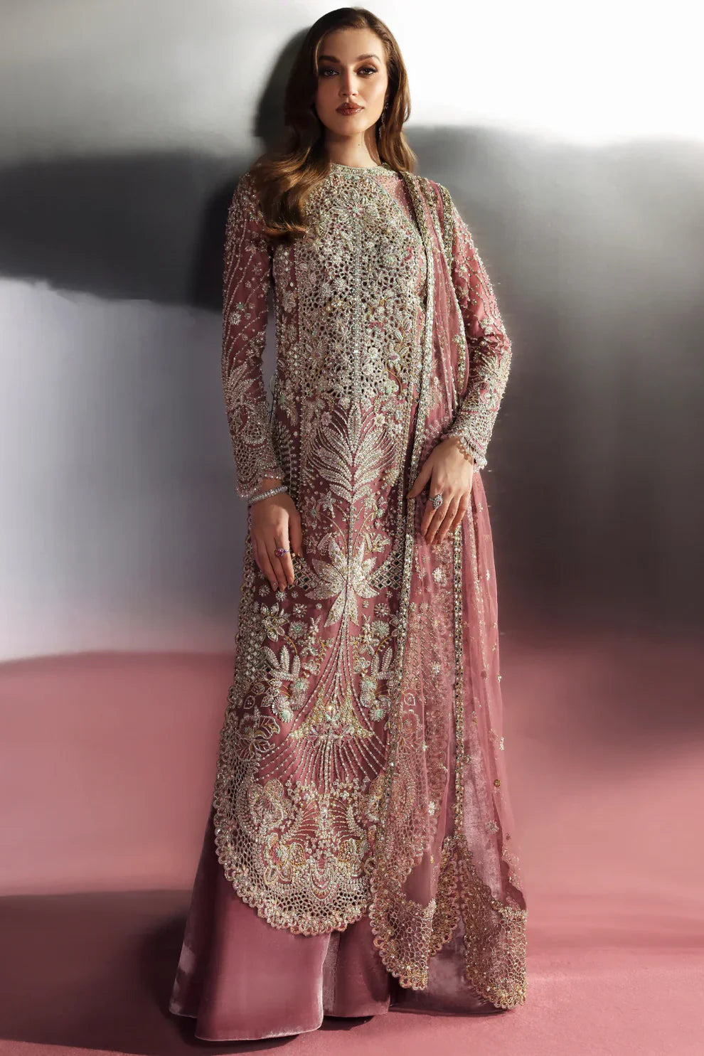 Velisse Soraya luxury dusty rose pink couture formal outfit front view featuring heavily hand-embellished organza shirt with intricate zari, naqshi, dabka, sequins and crystal embroidery arranged in royal symmetrical bridal pattern, richly detailed neckline and sleeves with fine resham work, paired with flowing lehenga/gharara in soft blush rose tone and heavily embroidered organza dupatta with scalloped borders, antique gold finishing and mukaish spray, premium designer wedding dress perfect for bridal wea