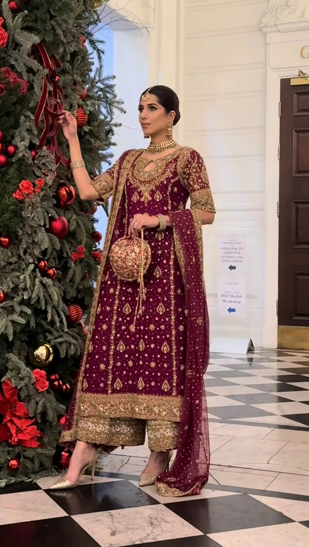 Libah by Haris Shakeel luxury formal outfit front view featuring deep maroon raw silk shirt with heavy all-over gold hand embroidery including intricate floral motifs, zari, resham and sequins work, elegant straight silhouette with richly decorated sleeves and ornate border finishing, paired with champagne toned straight trousers and sheer organza dupatta with subtle booti spray and detailed embroidered pallu, premium Pakistani designer outfit perfect for weddings, festive occasions, mehndi.