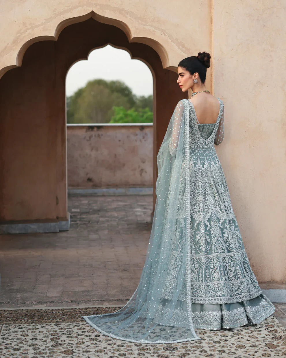 Dorien by Faiza Saqlain luxury mint blue bridal couture outfit front view featuring heavily hand-embellished net pishwas with intricate sequins, stones and resham embroidery in delicate floral heritage patterns, elegantly structured bodice with fitted sleeves and flowing flare silhouette, paired with richly embellished tissue lehenga featuring ornate embroidered borders and layered detailing, completed with heavily decorated net dupatta with all over sequin spray and four sided embroidered edging.