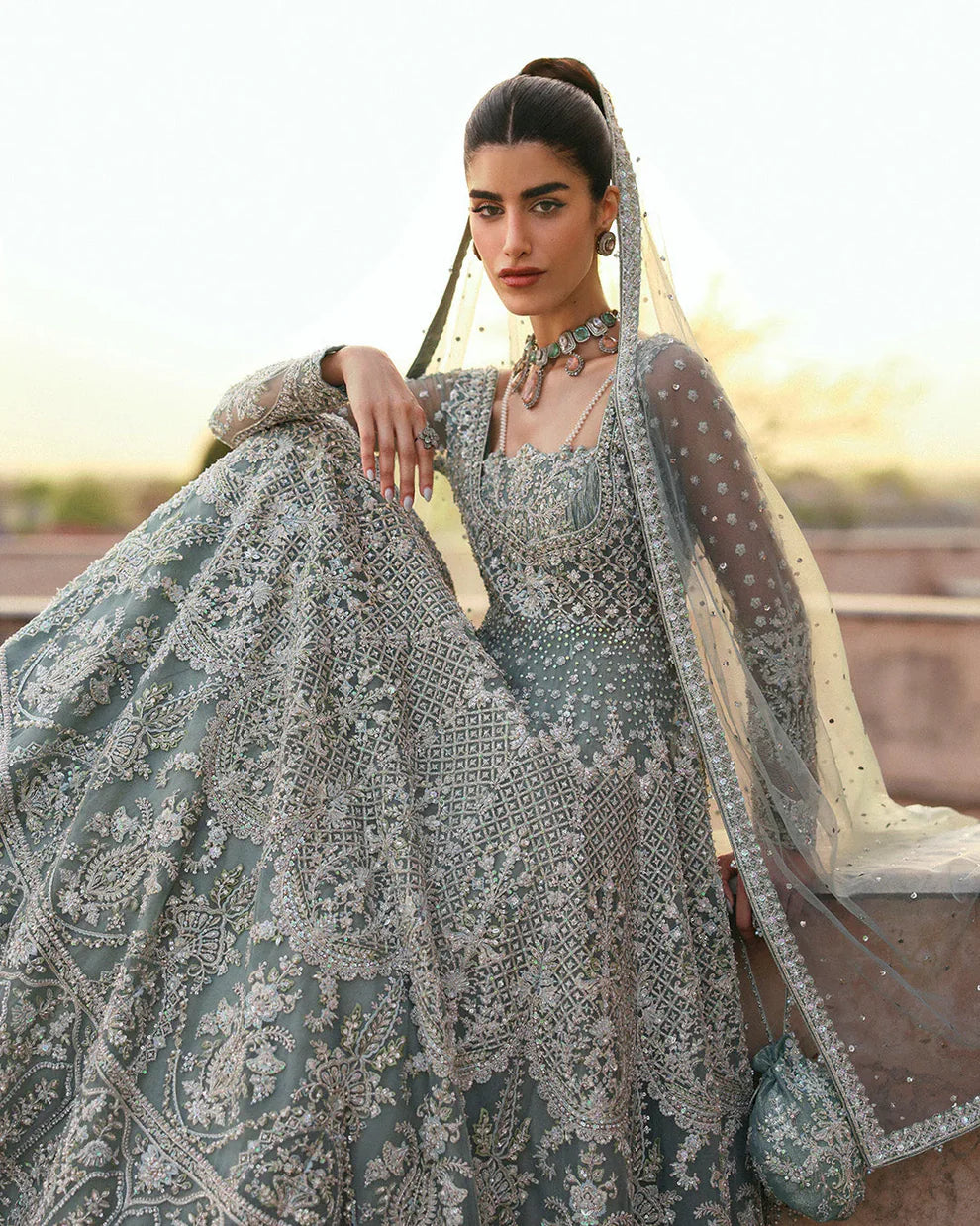 Dorien by Faiza Saqlain luxury mint blue bridal couture outfit front view featuring heavily hand-embellished net pishwas with intricate sequins, stones and resham embroidery in delicate floral heritage patterns, elegantly structured bodice with fitted sleeves and flowing flare silhouette, paired with richly embellished tissue lehenga featuring ornate embroidered borders and layered detailing, completed with heavily decorated net dupatta with all over sequin spray and four sided embroidered edging.