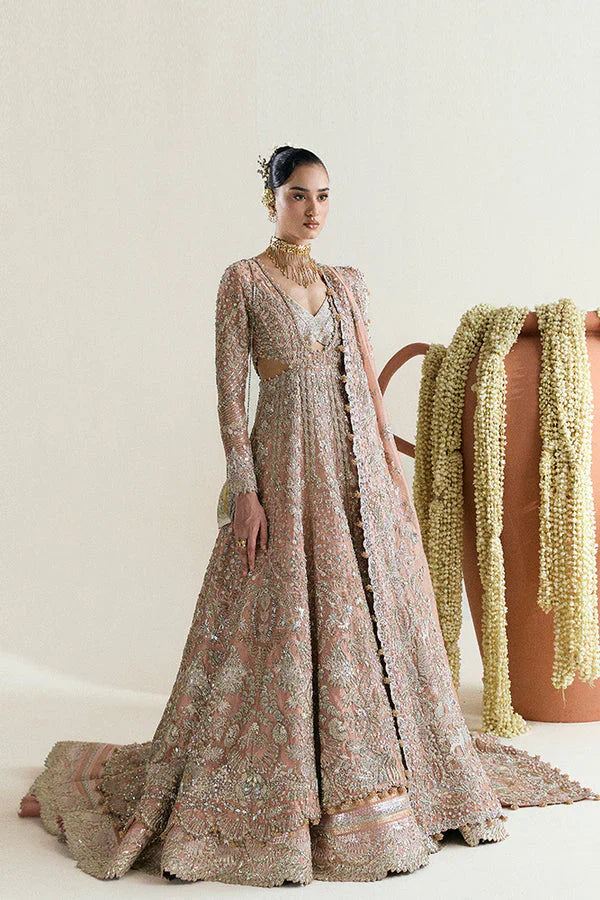 Suffuse Mahveen luxury bridal pishwas outfit front view featuring heavily hand-embellished tissue pishwas with fitted sleeves and layered bustier neckline, adorned with intricate mirror work, gota, resham and floral embroidery in sage green and gold accents, paired with richly panelled lehenga featuring ornate golden silver border detailing, completed with shikargah inspired tissue dupatta with geometric patterns, mirror work and four sided embroidered edges, premium Pakistani bridal couture.