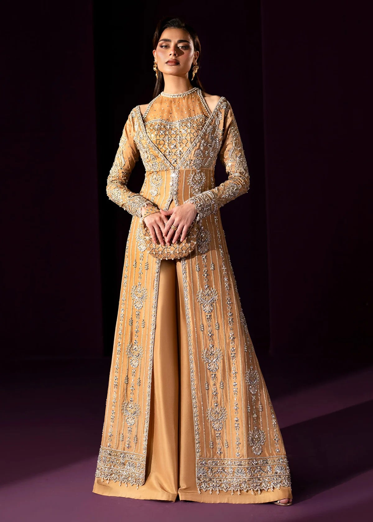 Oriana by Dastoor luxury couture formal outfit front view featuring nude gold tissue silk A-line gown with sheer halter bodice and structured neckline, heavily embellished with Swarovski crystals, pearls, sequins and fine hand embroidery arranged in elegant scattered constellation pattern, flowing silhouette with soft flare drape paired with matching palazzo pants in premium silk fabric, high-end designer outfit perfect for weddings, receptions, evening events and luxury formal occasions
