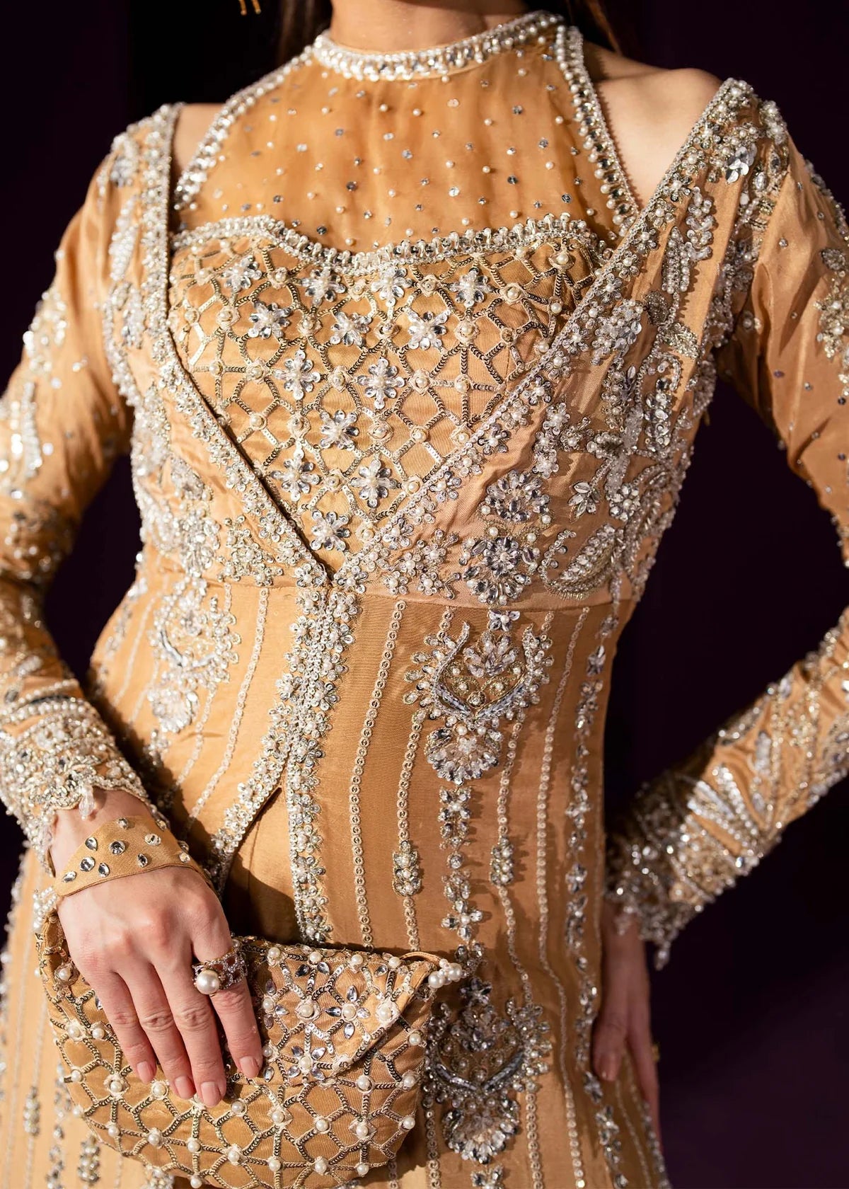 Oriana by Dastoor luxury couture formal outfit front view featuring nude gold tissue silk A-line gown with sheer halter bodice and structured neckline, heavily embellished with Swarovski crystals, pearls, sequins and fine hand embroidery arranged in elegant scattered constellation pattern, flowing silhouette with soft flare drape paired with matching palazzo pants in premium silk fabric, high-end designer outfit perfect for weddings, receptions, evening events and luxury formal occasions