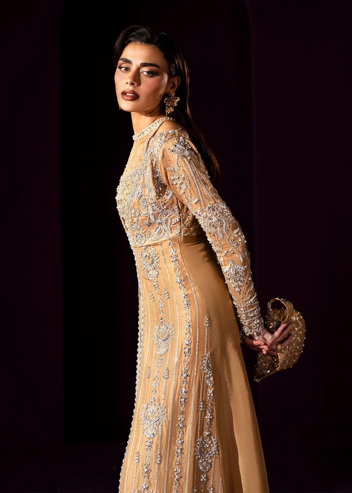 Oriana by Dastoor luxury couture formal outfit front view featuring nude gold tissue silk A-line gown with sheer halter bodice and structured neckline, heavily embellished with Swarovski crystals, pearls, sequins and fine hand embroidery arranged in elegant scattered constellation pattern, flowing silhouette with soft flare drape paired with matching palazzo pants in premium silk fabric, high-end designer outfit perfect for weddings, receptions, evening events and luxury formal occasions