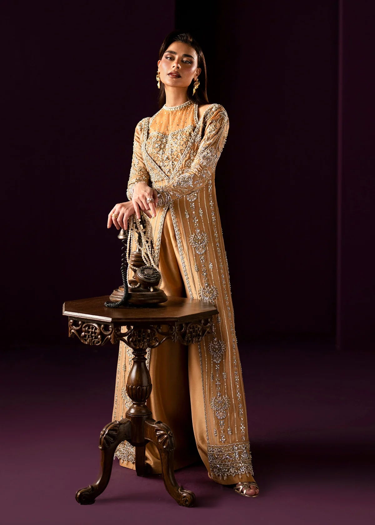 Oriana by Dastoor luxury couture formal outfit front view featuring nude gold tissue silk A-line gown with sheer halter bodice and structured neckline, heavily embellished with Swarovski crystals, pearls, sequins and fine hand embroidery arranged in elegant scattered constellation pattern, flowing silhouette with soft flare drape paired with matching palazzo pants in premium silk fabric, high-end designer outfit perfect for weddings, receptions, evening events and luxury formal occasions