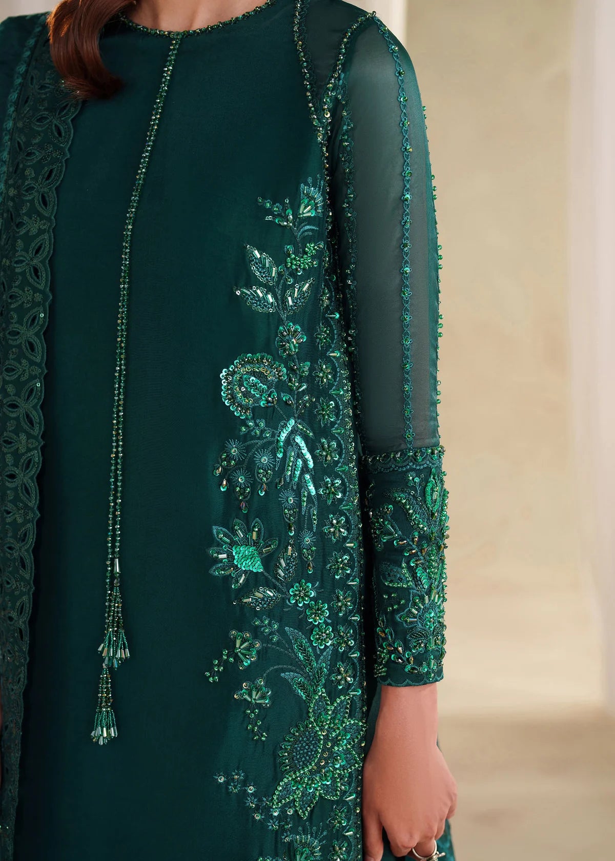 Eiza Dastoor luxury formal outfit front view featuring elegant ivory white raw silk shirt with heavy hand embroidery including intricate floral motifs, resham, sequins, kora and dabka embellishments arranged in refined symmetrical pattern, delicately detailed neckline and sleeve borders with fine craftsmanship, paired with matching straight trousers and soft organza dupatta with embroidered edges and light sequin spray, premium Pakistani designer outfit perfect for weddings, engagements, festive occasions 