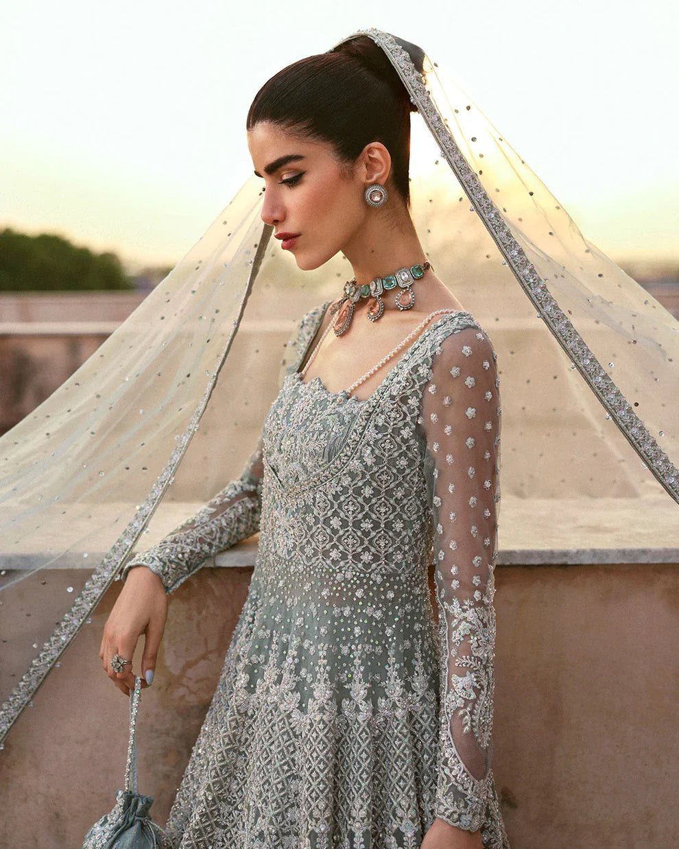 Dorien by Faiza Saqlain luxury mint blue bridal couture outfit front view featuring heavily hand-embellished net pishwas with intricate sequins, stones and resham embroidery in delicate floral heritage patterns, elegantly structured bodice with fitted sleeves and flowing flare silhouette, paired with richly embellished tissue lehenga featuring ornate embroidered borders and layered detailing, completed with heavily decorated net dupatta with all over sequin spray and four sided embroidered edging.