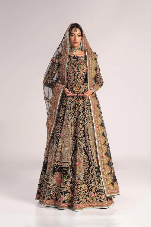 Ajooba by Fahad Hussayn luxury black bridal couture outfit front view featuring heavily hand-embellished net lehenga and blouse with intricate resham, zardozi, naqshi, dabka and crystal embroidery forming rich floral Mughal inspired patterns, dramatic structured silhouette with full flare lehenga and detailed choli, paired with sheer organza dupatta scattered with delicate floral motifs and ornate embroidered border finishing, premium high-end bridal ensemble perfect for weddings, receptions etc