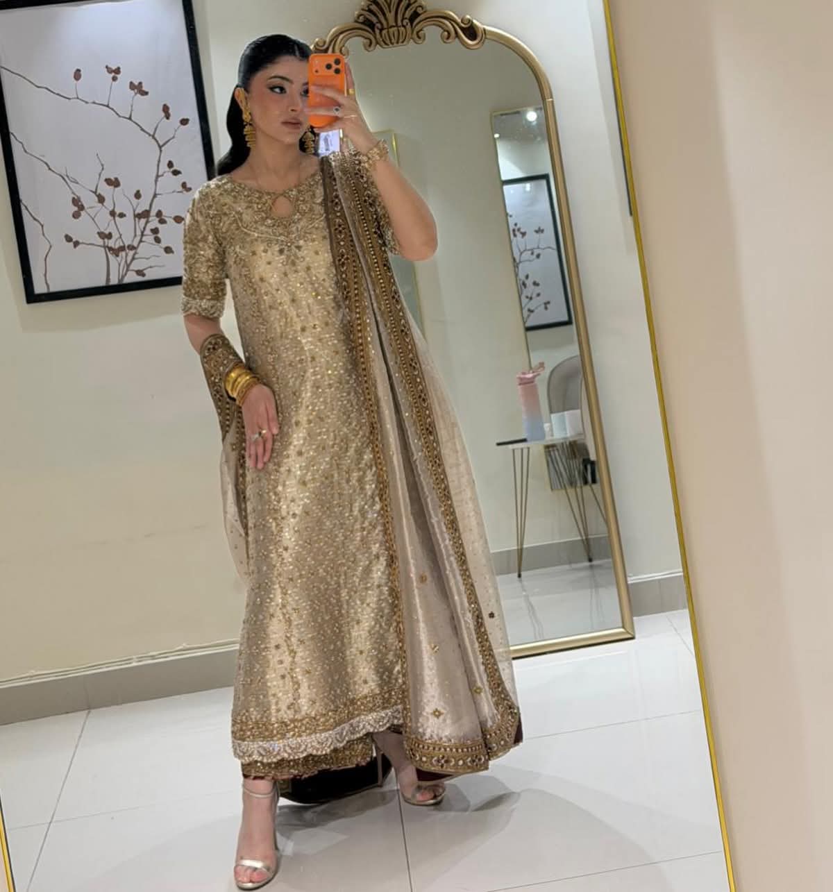 Front view of Nooré Champagne Royale by Bisma Noor featuring champagne gold hand embellishments, intricate zari detailing, and an embroidered luxury formal silhouette