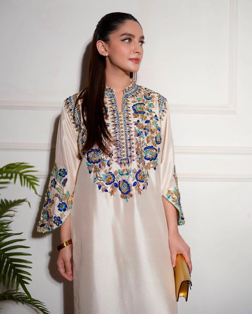 Elegant white designer embroidered suit with trousers
Premium Aleena Khan formal ensemble detailed embroidery close up
Aleena Khan white festive outfit full look for women