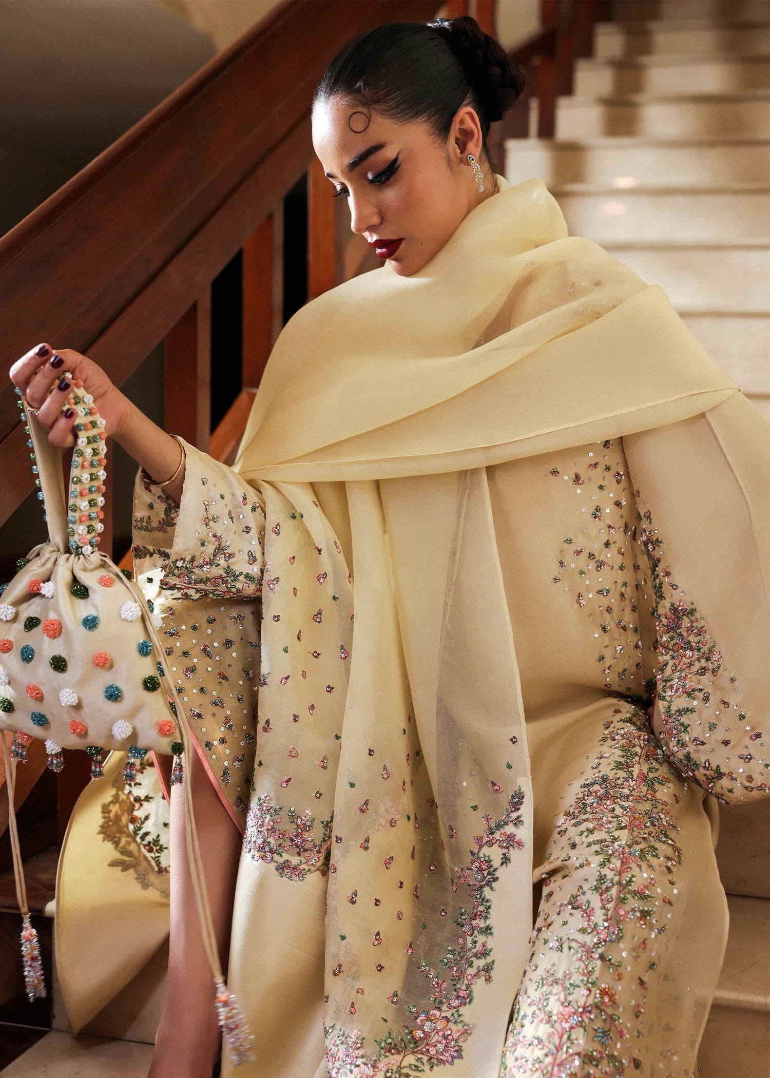 Close view of model wearing butter yellow embroidered Pakistani formal dress