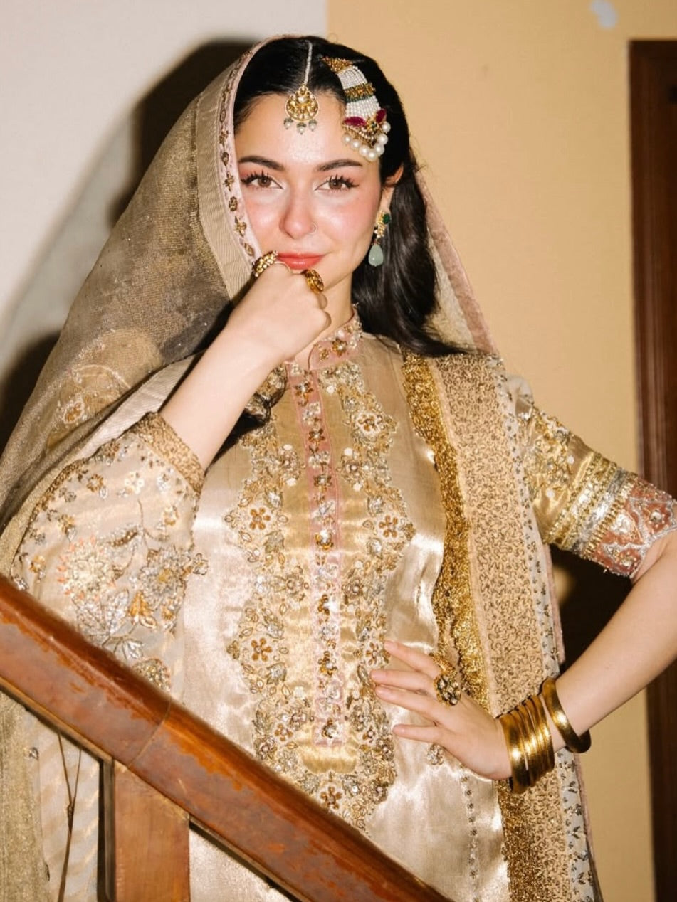 Close up of intricate dabka, zari and crystal handwork on golden bridal outfit