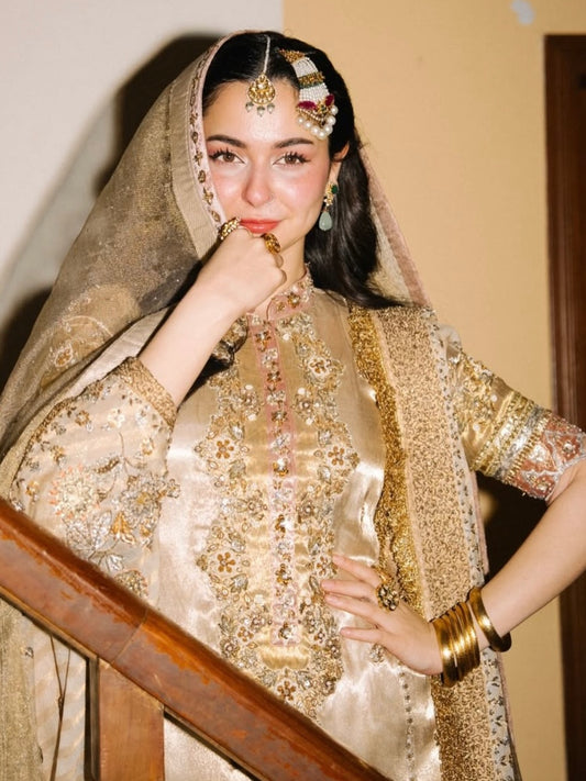 Close up of intricate dabka, zari and crystal handwork on golden bridal outfit