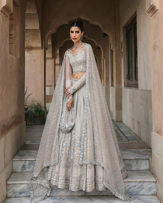 Woman wearing Faiza Saqlain Cammi white embellished bridal lehenga choli front view