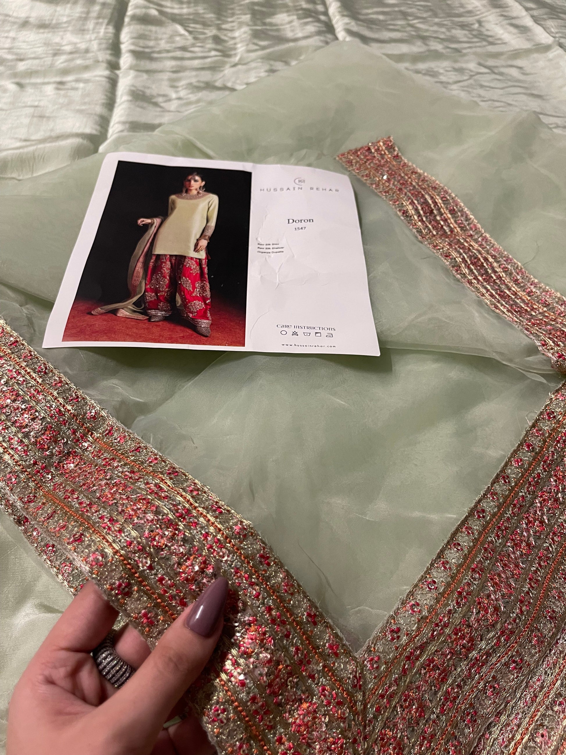 Close up of pistachio organza dupatta with sequin spray and border embroidery