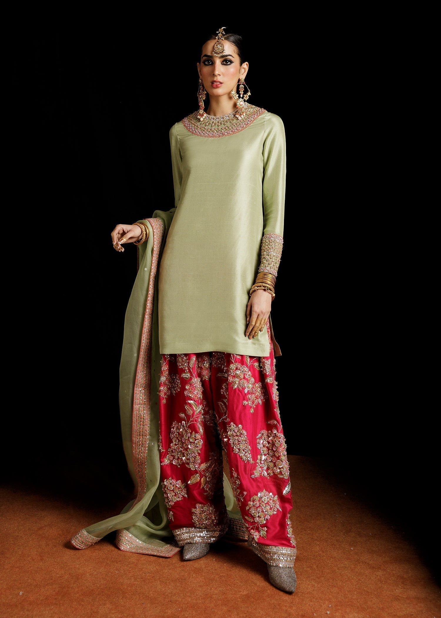 Front view of pistachio green embroidered Pakistani dress with hot pink shalwar and organza dupatta