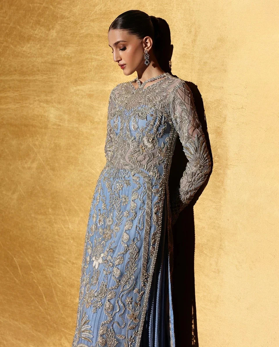 Full shirt view of Seralyn by Soraya with model looking down while leaning against wall, highlighting intricate hand embellished front design